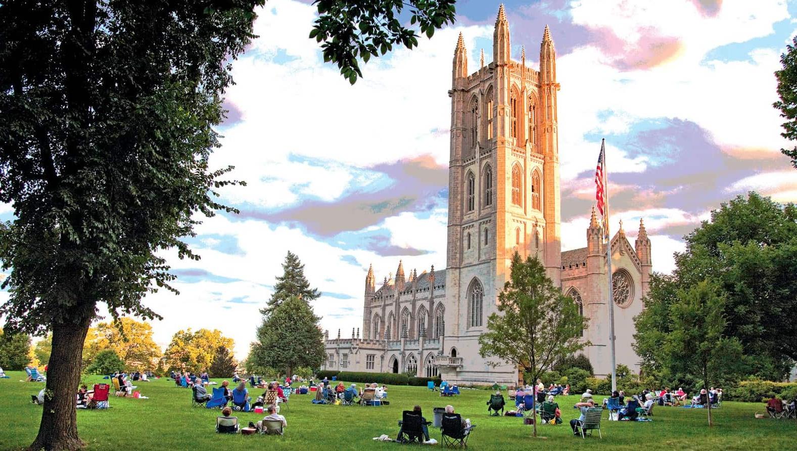 的 Trinity College Chapel with students sitting on the grass